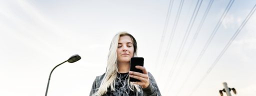 Young Woman Skater Browsing Phone Concept