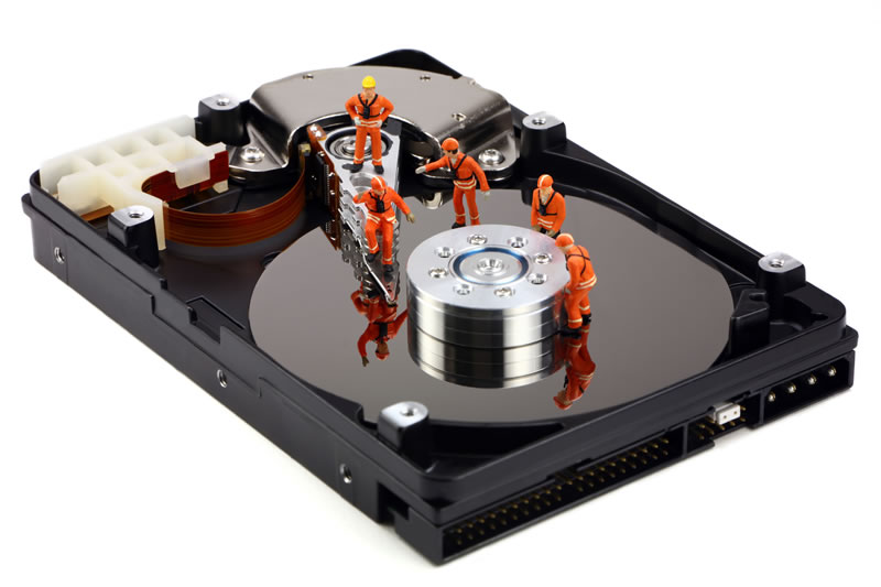 Another tech support concept of miniature technicians working on recovering data in a hard drive.