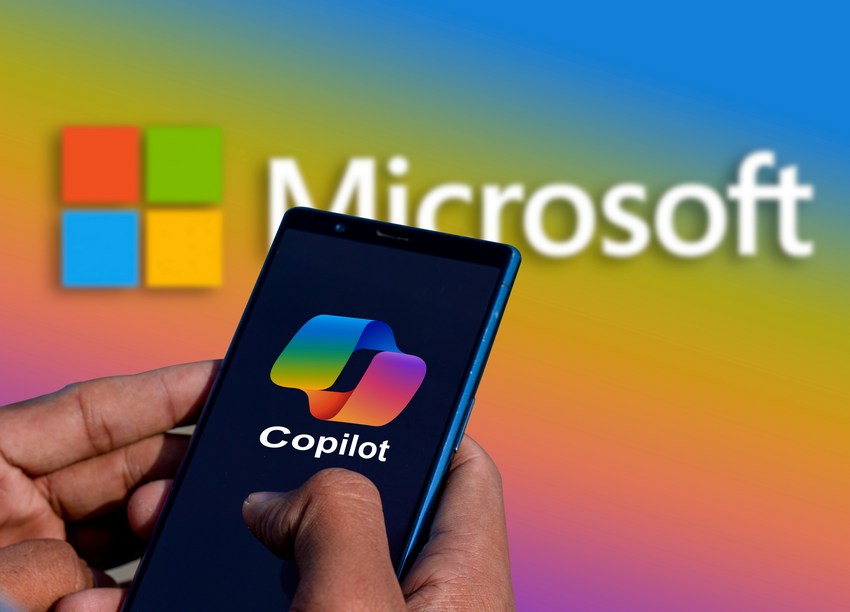 Copilot logo on a smartphone with Microsoft logo in background